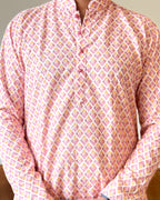 Pink patterned shirt worn by a person on a neutral background