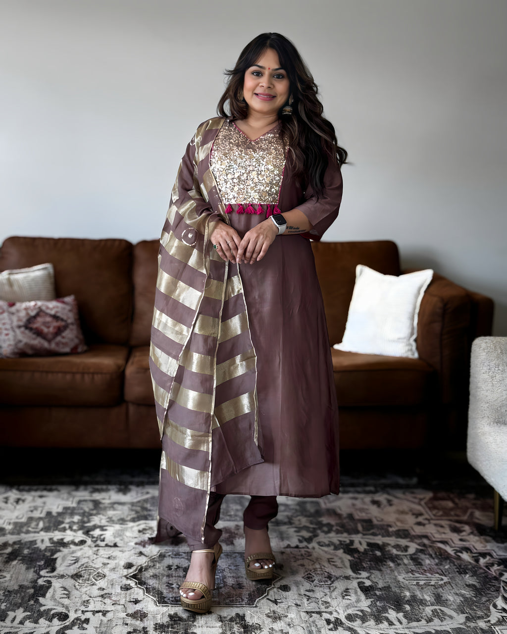 Brown Mul Chanderi women’s suit set with gold sequin yoke, pink tassel detailing and striped dupatta.