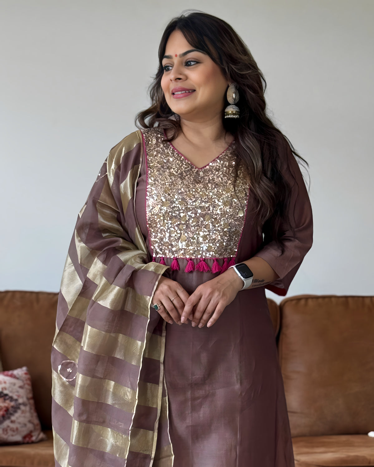 Brown Mul Chanderi women’s suit set with gold sequin yoke, pink tassel detailing and striped dupatta.