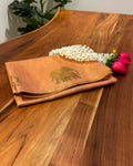 Folded fabric with a bull emblem on a wooden surface with flowers and berries.