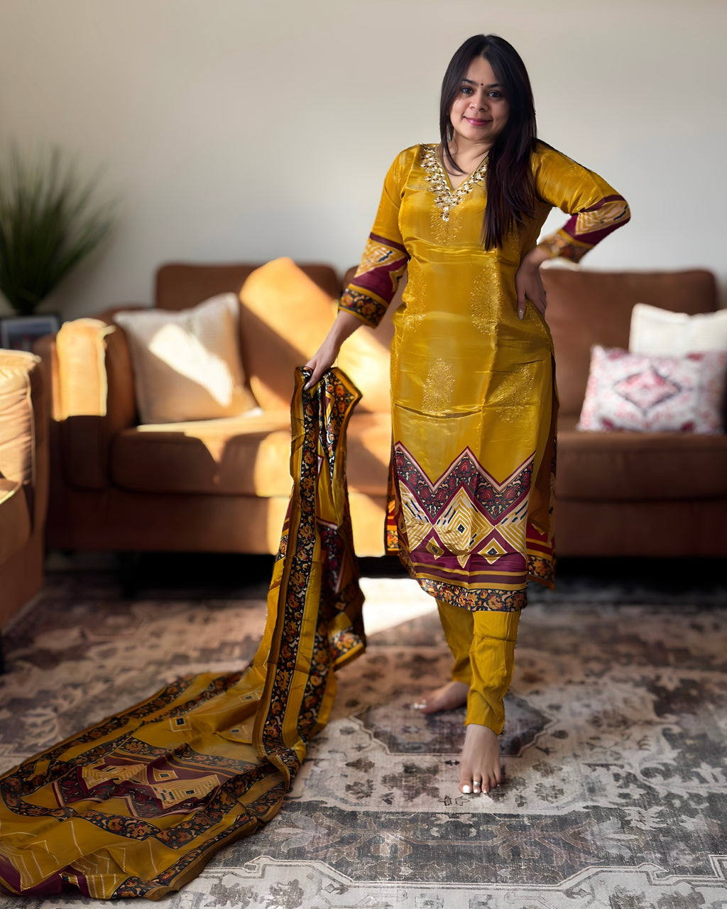 Woman in a yellow traditional outfit standing in a living room.