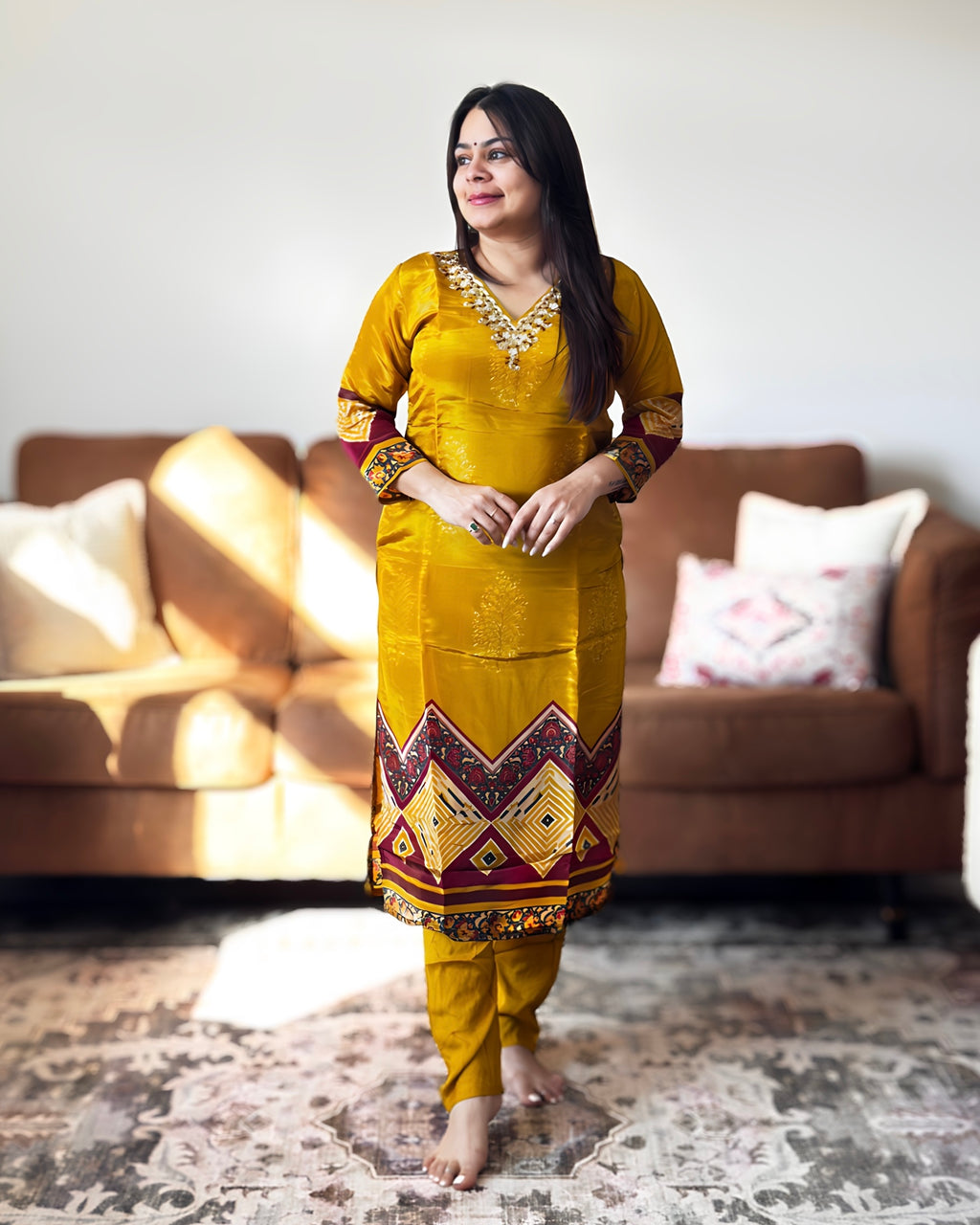 Woman in a yellow traditional outfit standing in a living room.