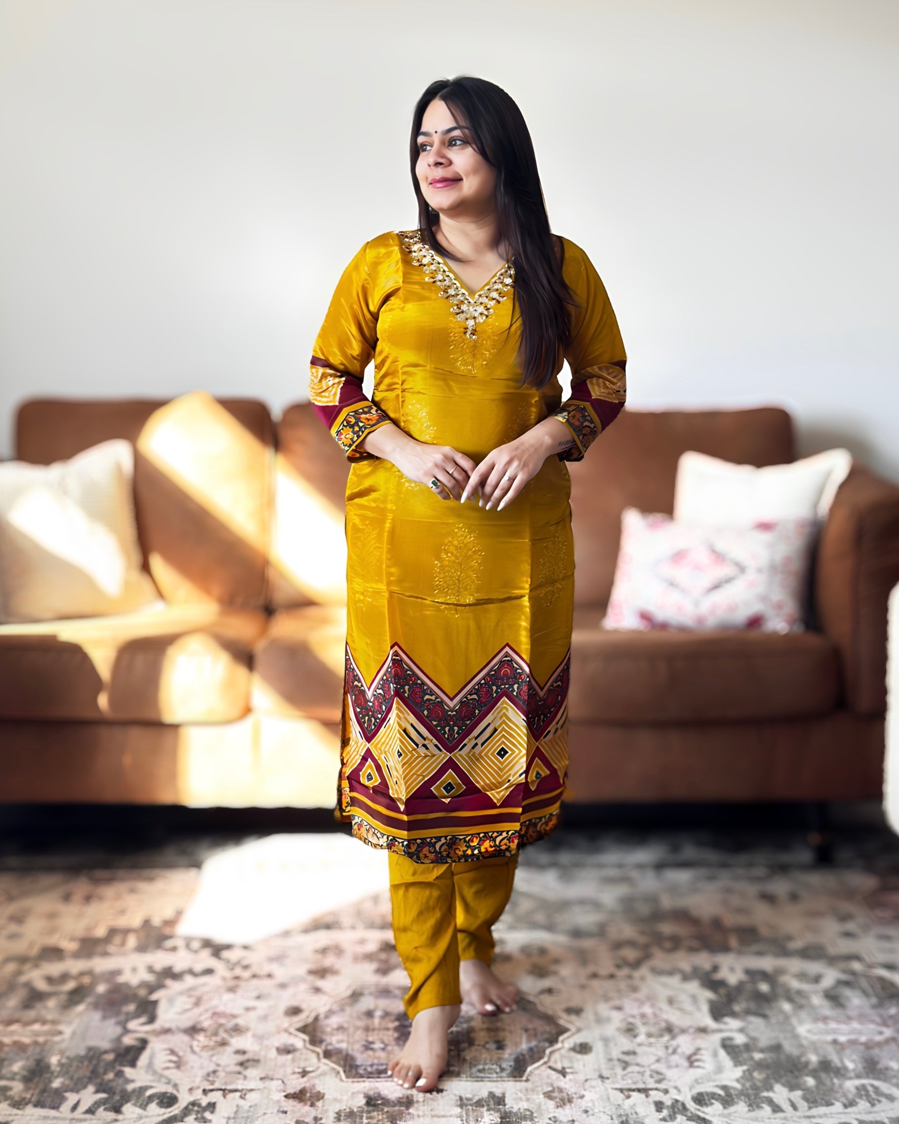 Woman in a yellow traditional outfit standing in a living room.