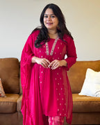 Woman in a red traditional outfit standing in a living room.