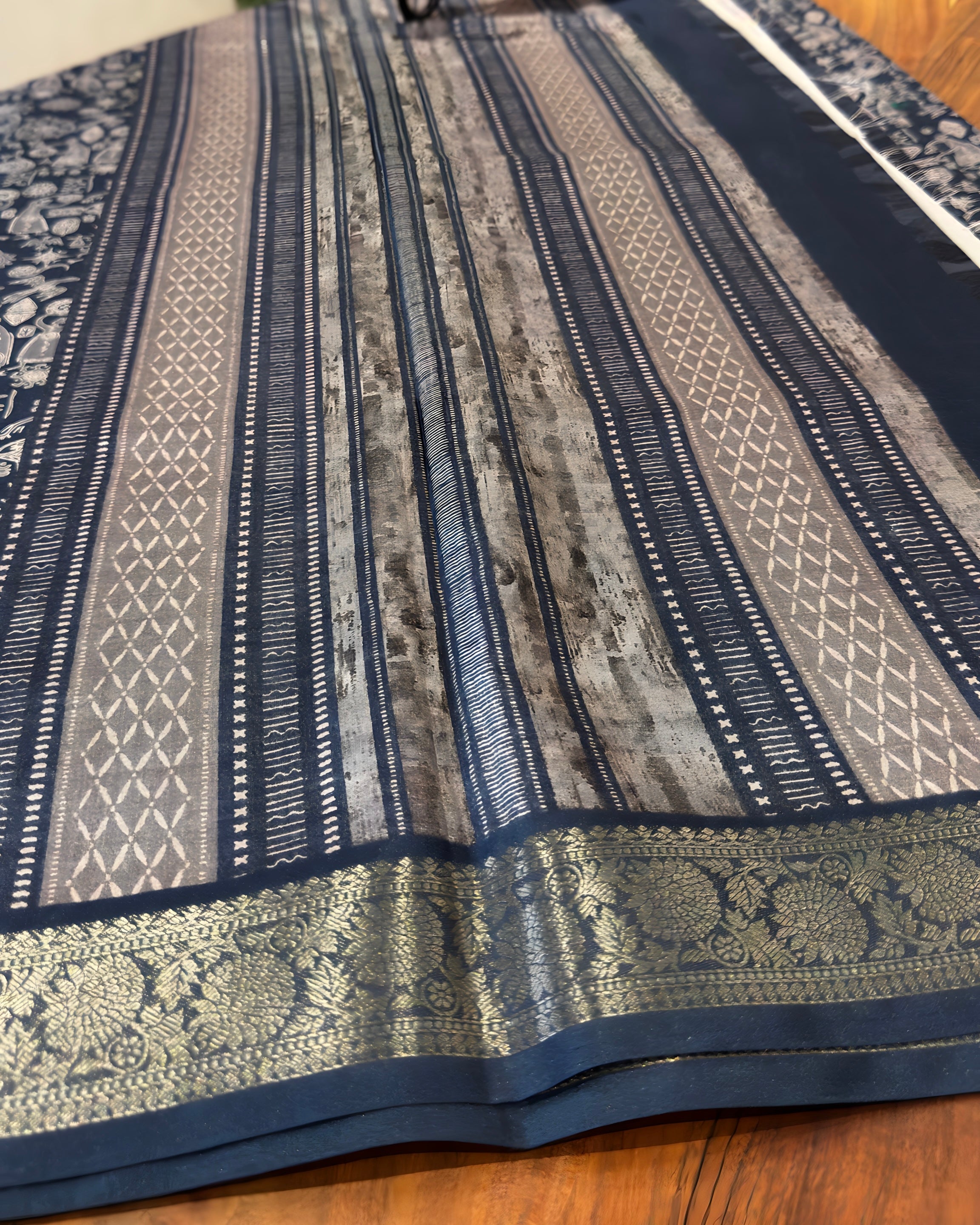 Patterned fabric with blue and beige stripes on a wooden surface