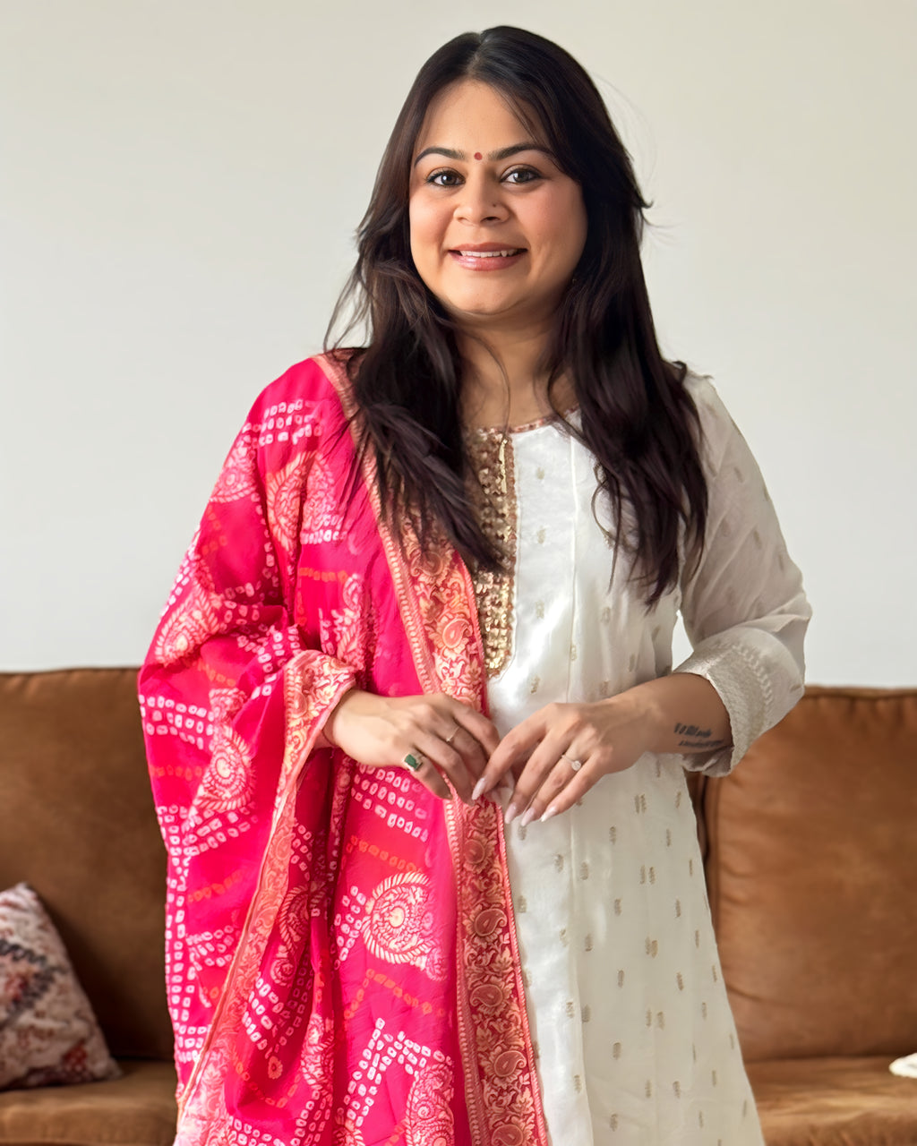 Woman wearing a pink and white traditional outfit with a neutral background