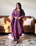 Woman in a purple traditional outfit standing in a living room.