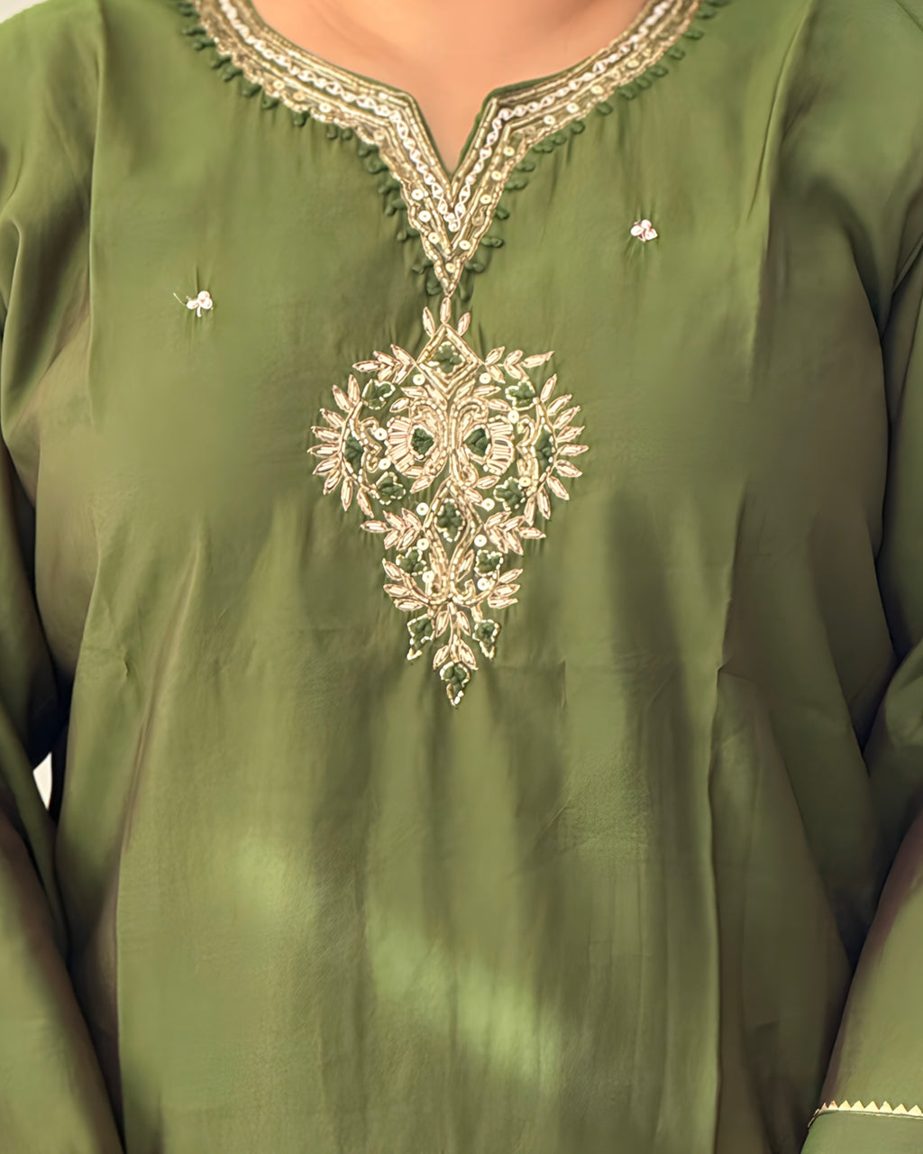 Green embroidered garment with intricate patterns