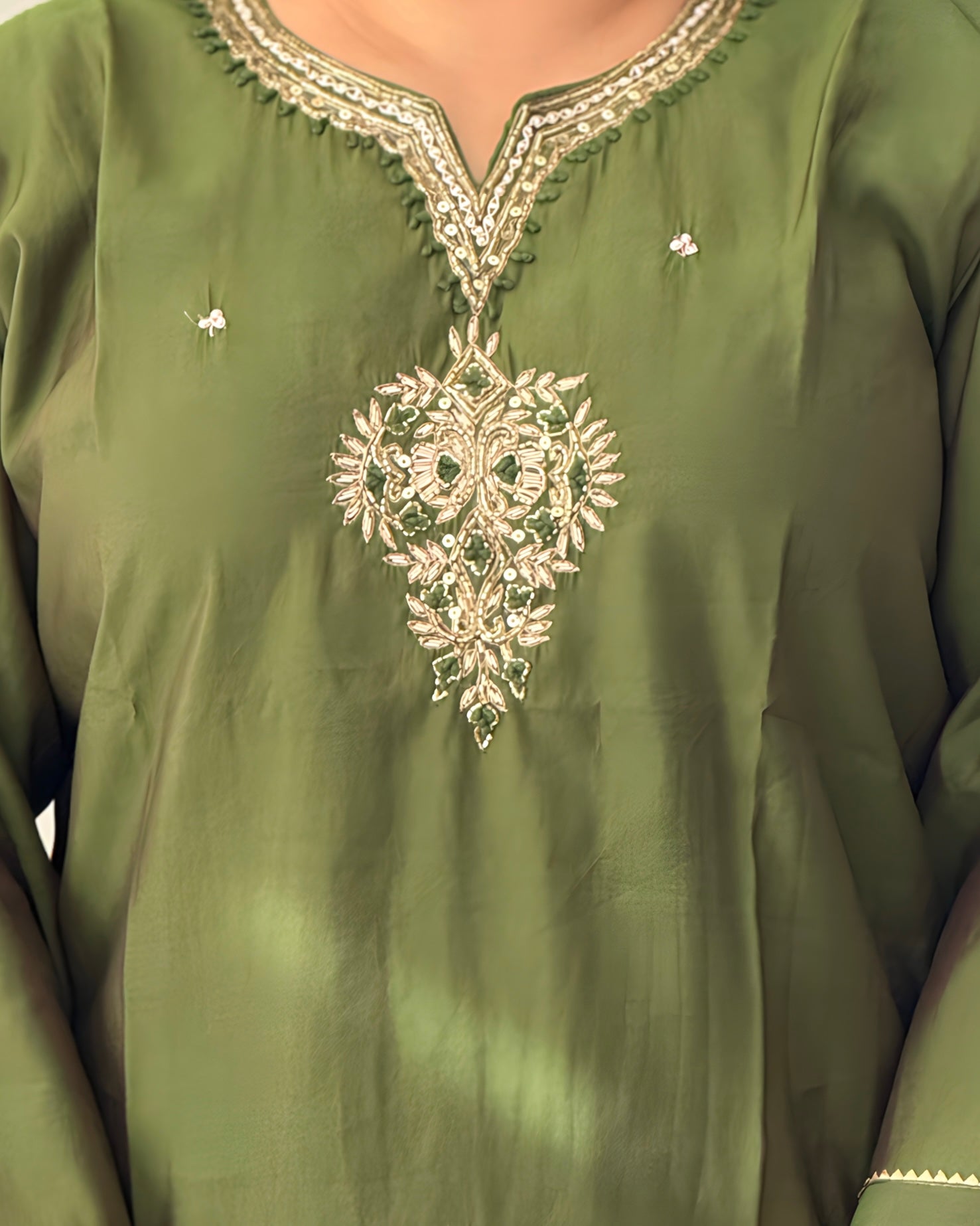 Green embroidered garment with intricate patterns
