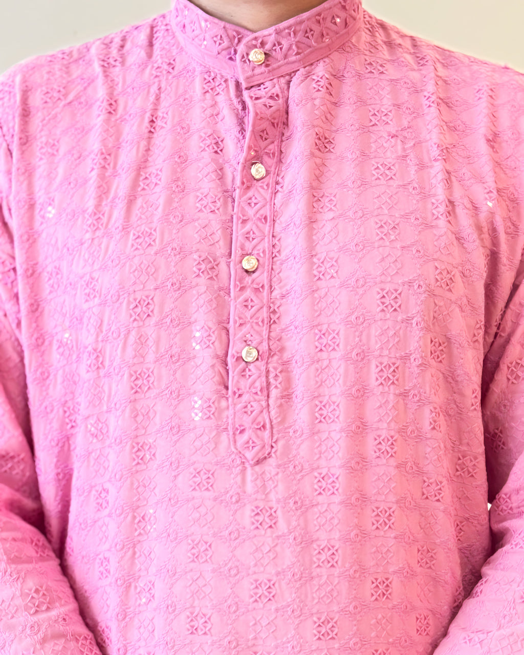 Close-up of a pink embroidered shirt with a plain background