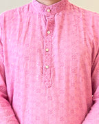 Close-up of a pink embroidered shirt with a plain background