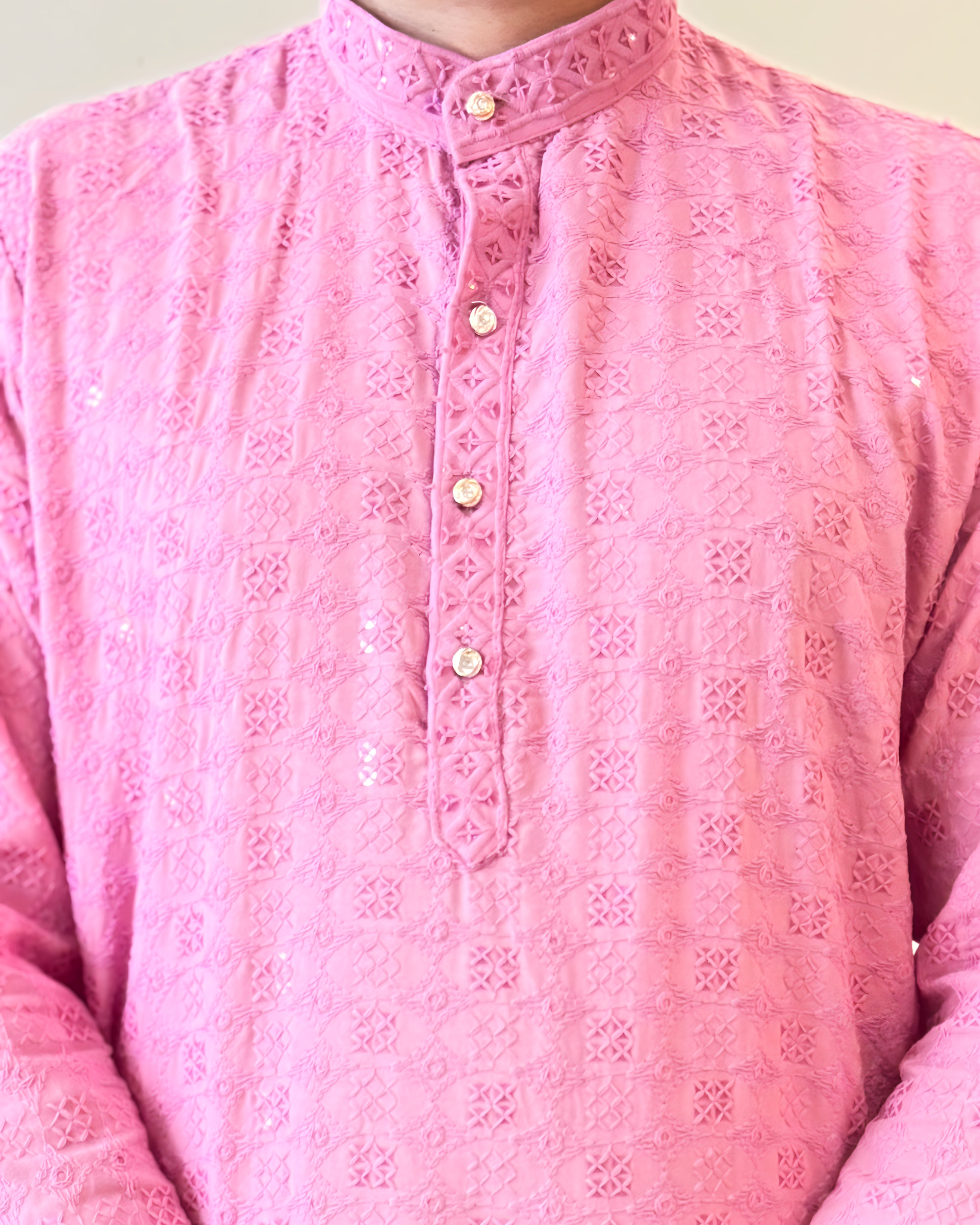 Close-up of a pink embroidered shirt with a plain background