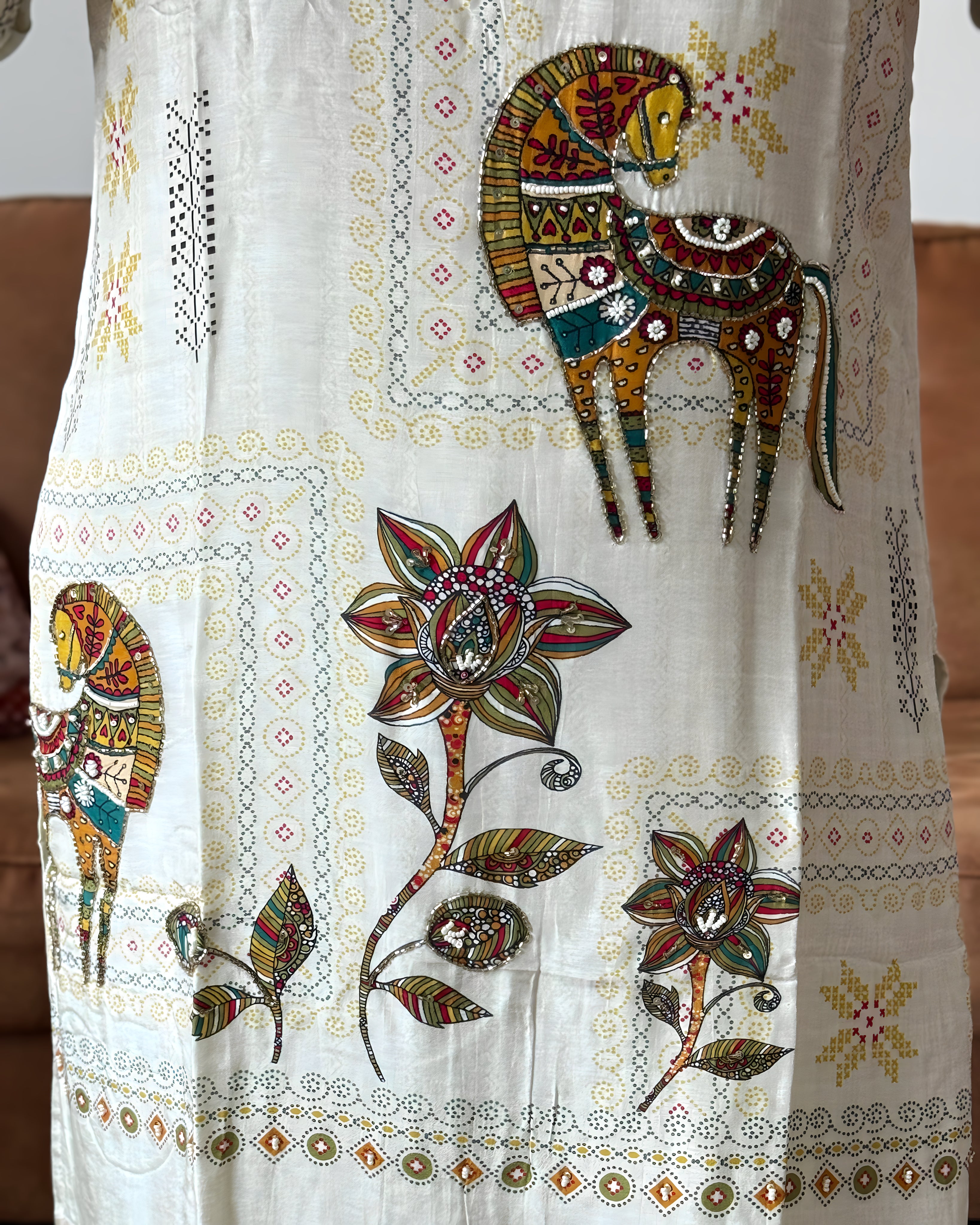Decorative fabric with embroidered animals and flowers on a white background