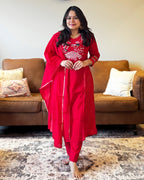 Woman in a red traditional outfit standing in a living room.