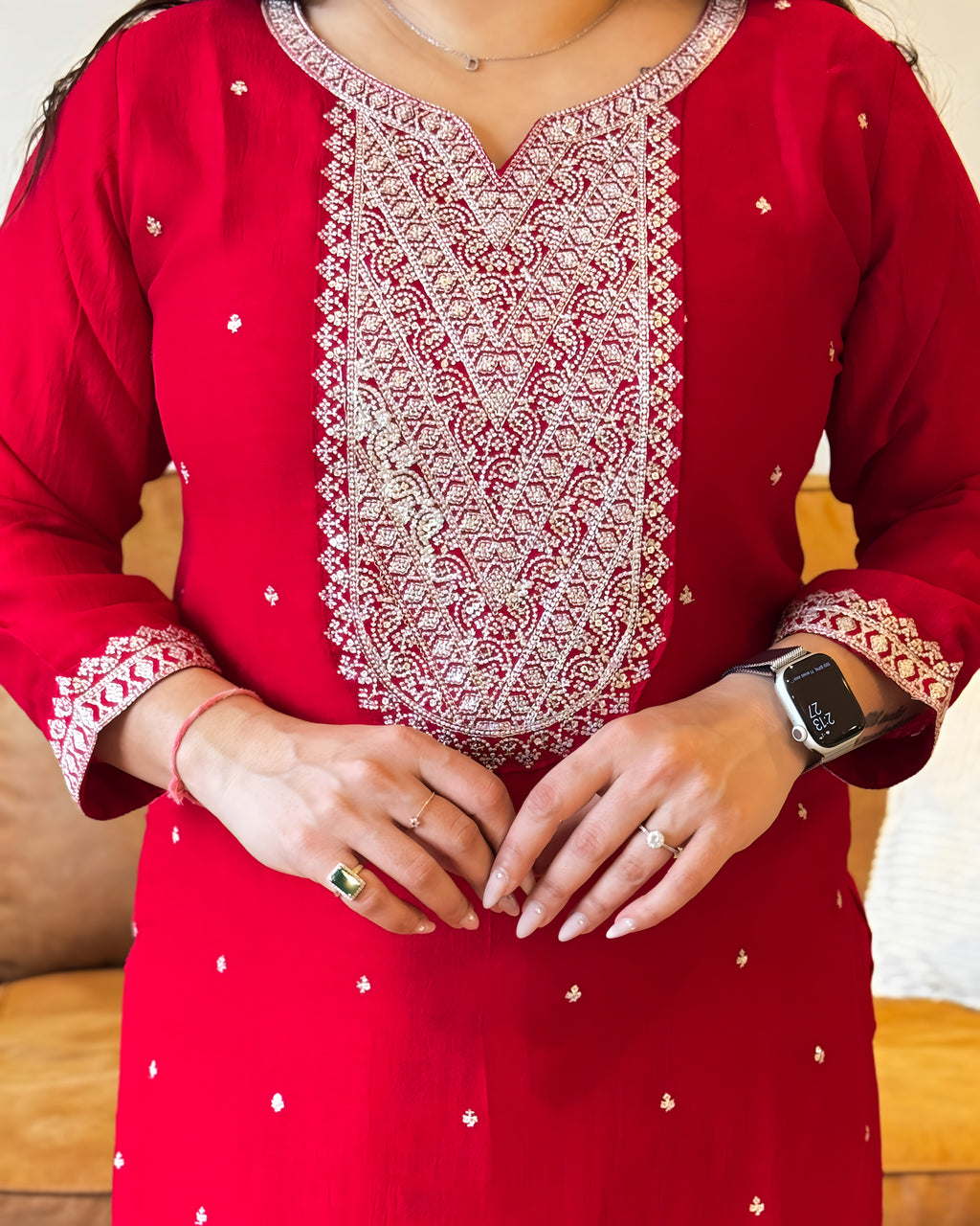 Red kurta with white embroidery and patterns worn by a person.