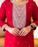 Red kurta with white embroidery and patterns worn by a person.