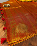 Red and gold traditional fabric with intricate patterns on a wooden surface